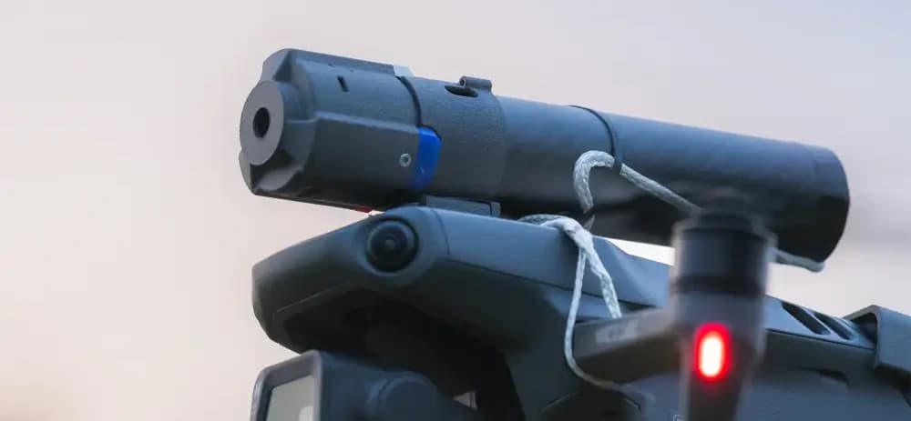 "En drönare utrustad med en monterad fallskärm, redo för teknisk användning i skymningsljus."