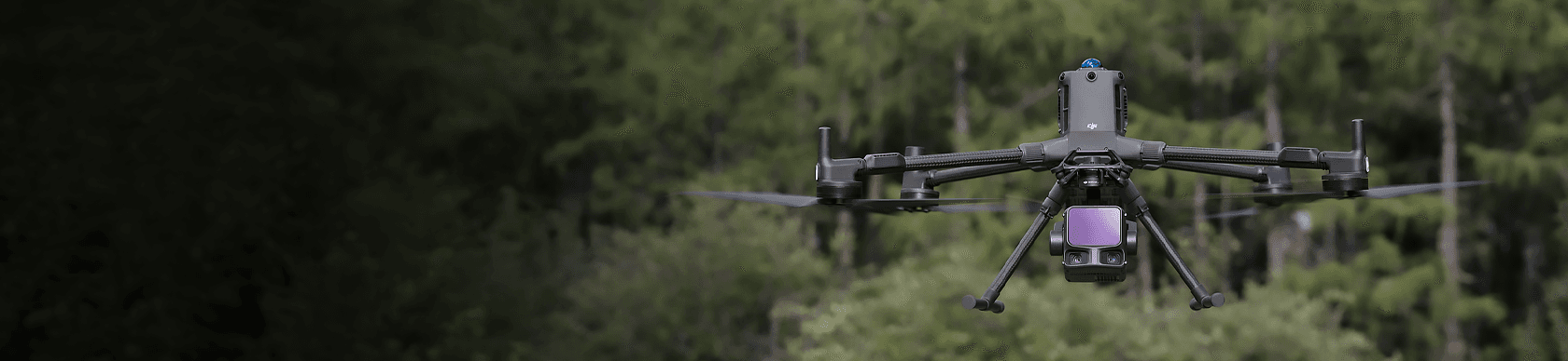 En drönare svävar över en skogsmiljö, redo för inspektionsarbete.