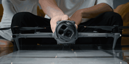 En person justerar en avancerad drönare med flera kameror, redo för flygning.