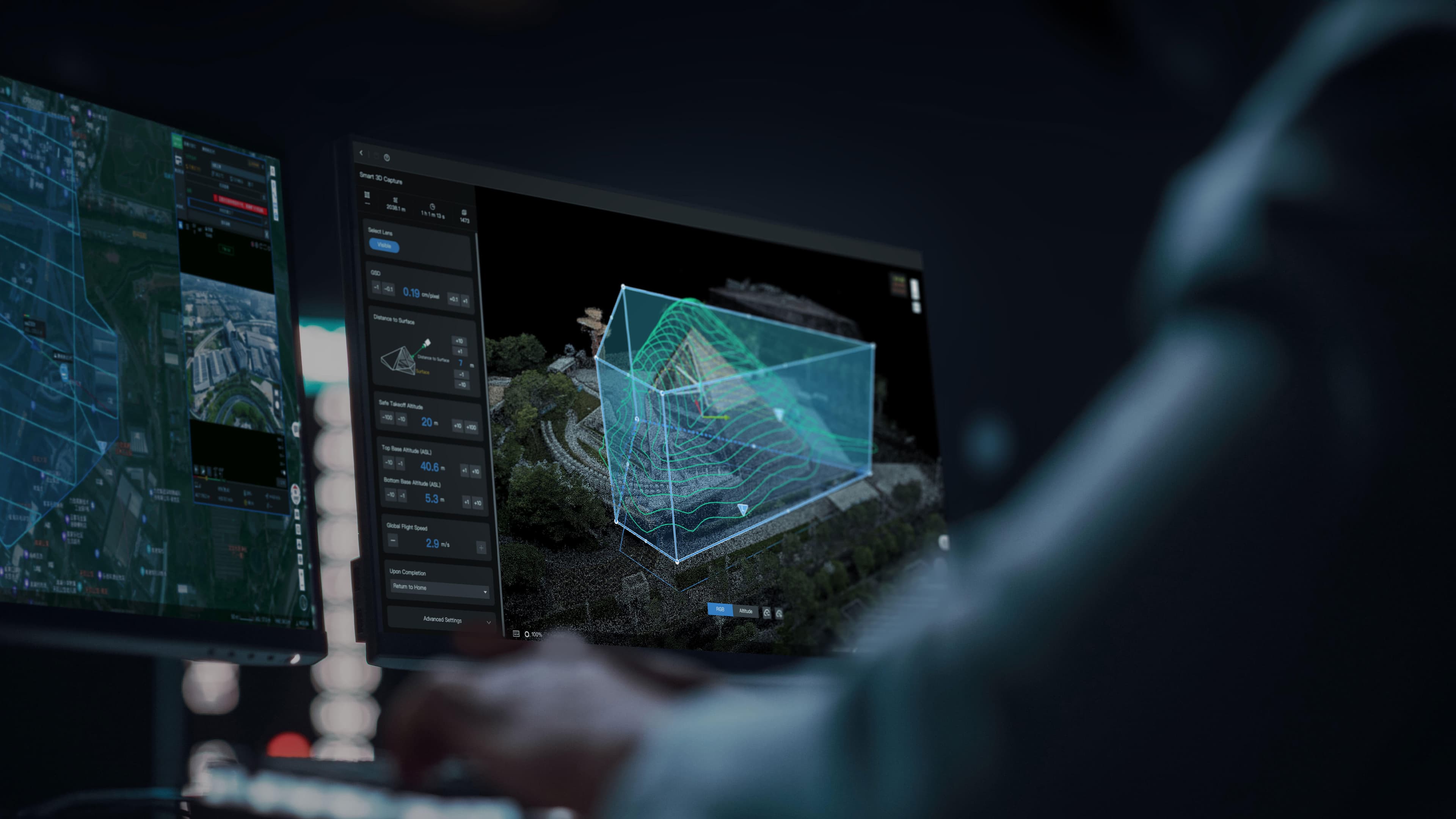 En person arbetar vid en dator med avancerad 3D-kartläggning och analys på skärmen, vilket visar topografiska data i en digital miljö.