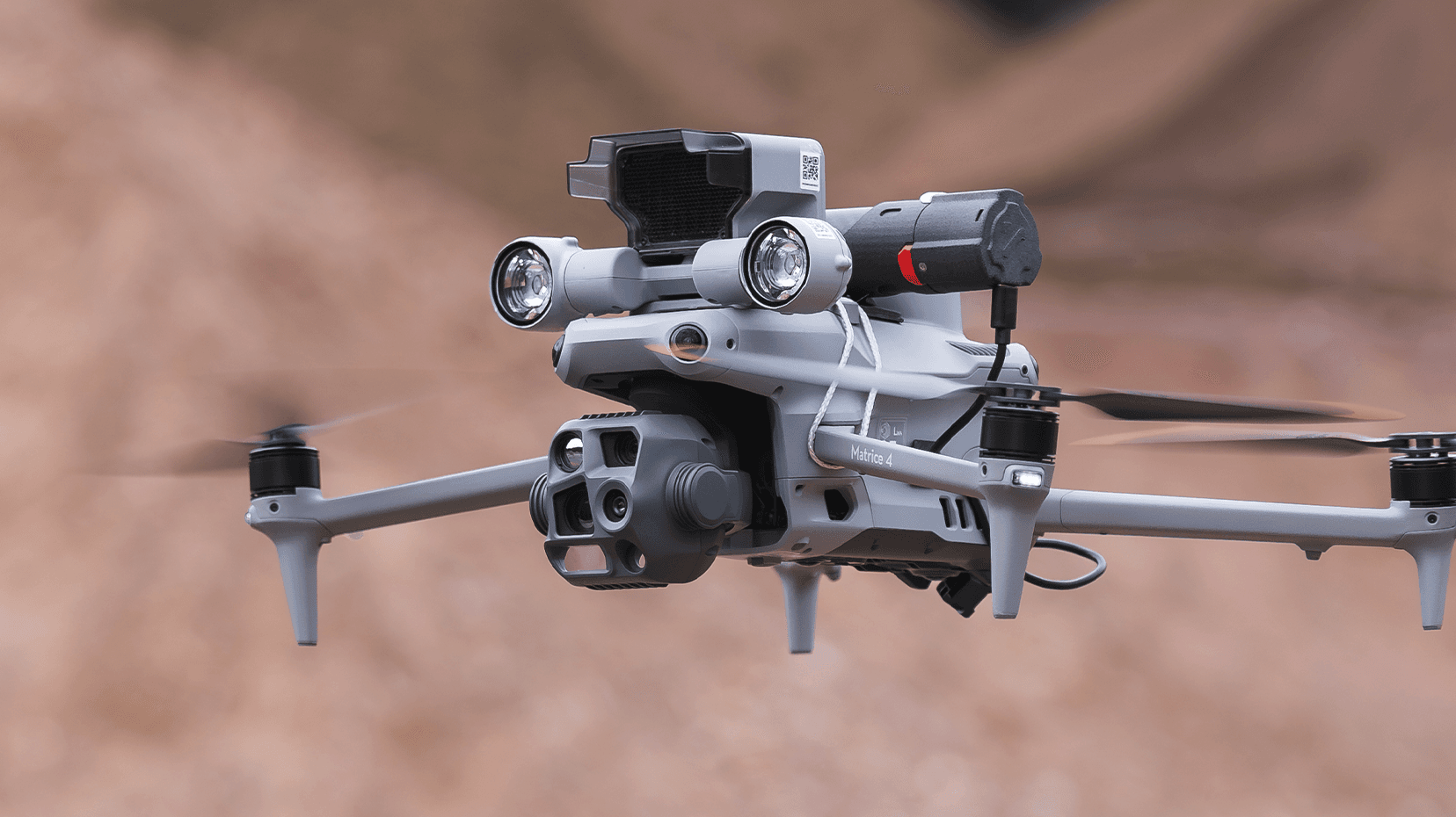 En avancerad drönare svävar i luften, utrustad med flera kameror och sensorer för övervakning och analys.