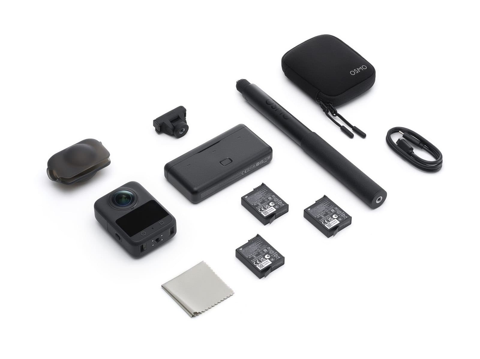 En actionkamera med tillbehör som batterier, en förlängningsstav, laddare och ett fodral, arrangerade på en vit bakgrund.